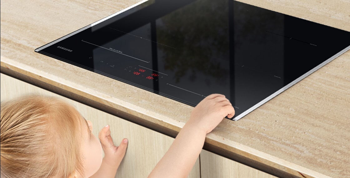 Zdjęcie dziecka przy kuchence wskazuje na zwiększony poziom bezpieczeństwa użytkowania dzięki blokadzie panelu sterowania