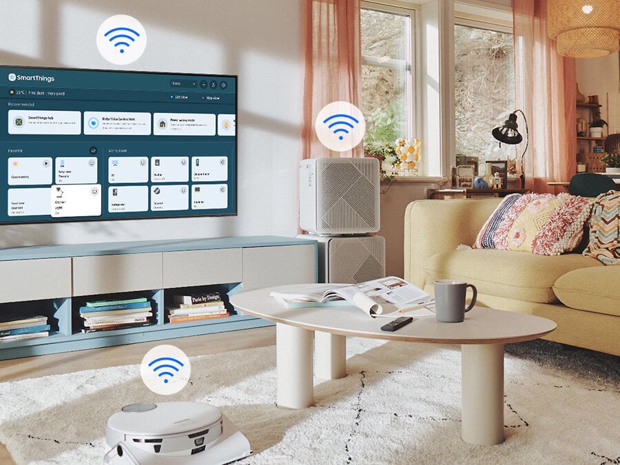 Na ekranie telewizora widać menu SmartThings. Ikonki WiFi pokazane nad telewizorem, odkurzaczem samojezdnym i oczyszczaczem powietrza. Q77BATXXH