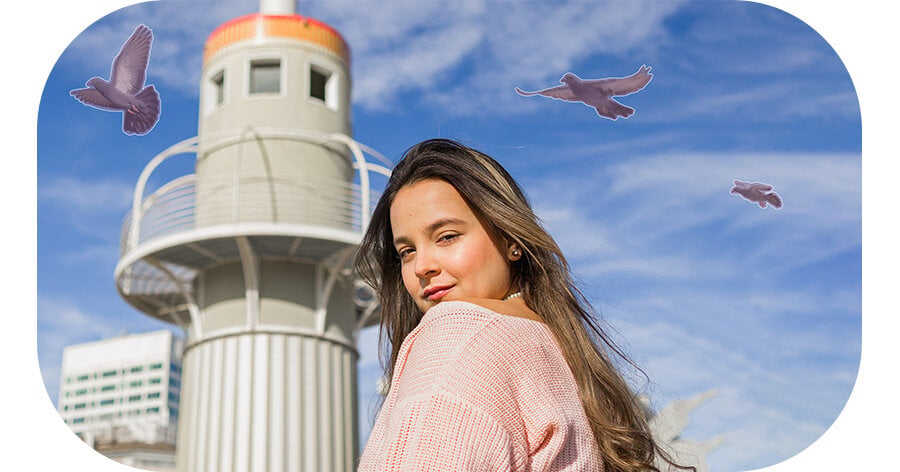 Portretowe ujęcie kobiety patrzącej na aparat z ptakiem lecącym w tle na niebieskim niebie. Po zastosowaniu narzędzia Object Eraser ptak zostaje wymazany z tła. 