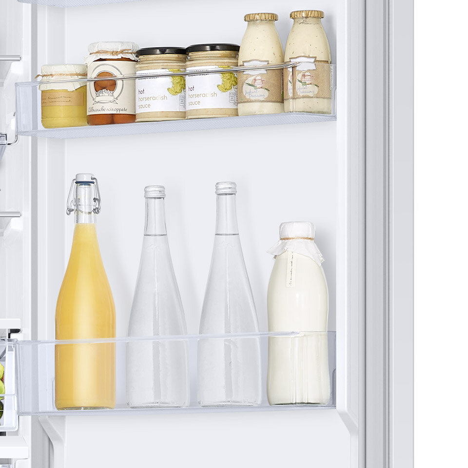 Zdjęcie drzwi chłodziarki z umieszczonymi tu pojemnikami, w których wygodnie przechowasz słoiki z przetworami i butelki z mlekiem