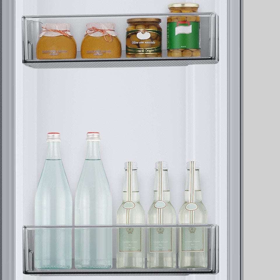 Przetwory owocowe oraz butelki z napojami umieszczone w głębokich pojemnikach drzwiowych
