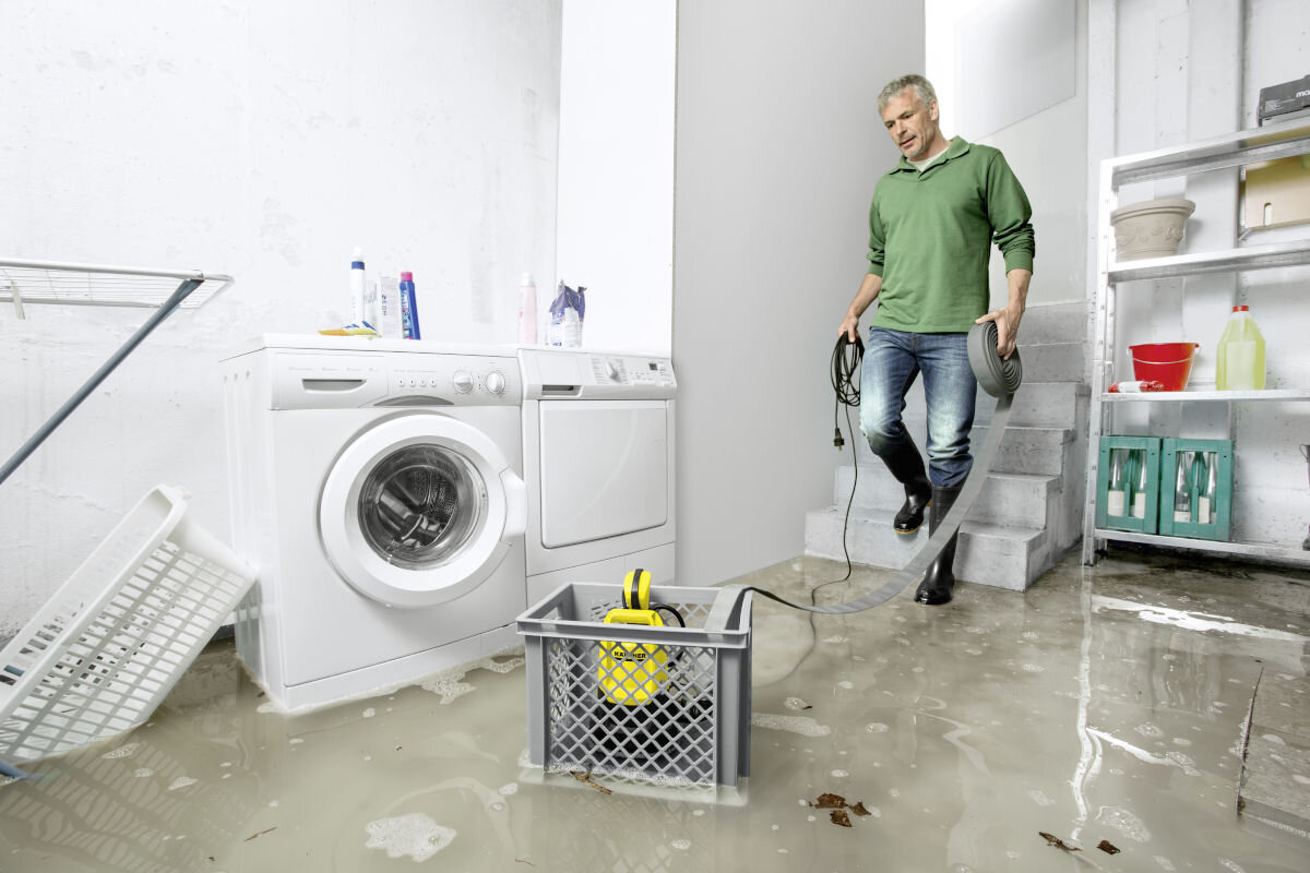 Pompa zanurzeniowa do wody brudnej KARCHER SP 22.000 Flood Box elektryczna 1.645-853.0, pompa, woda, odprowadzanie, zalanie, piwnica, mężczyzna schodzi na dół do piwnicy, po środku pracuje pompa karcher