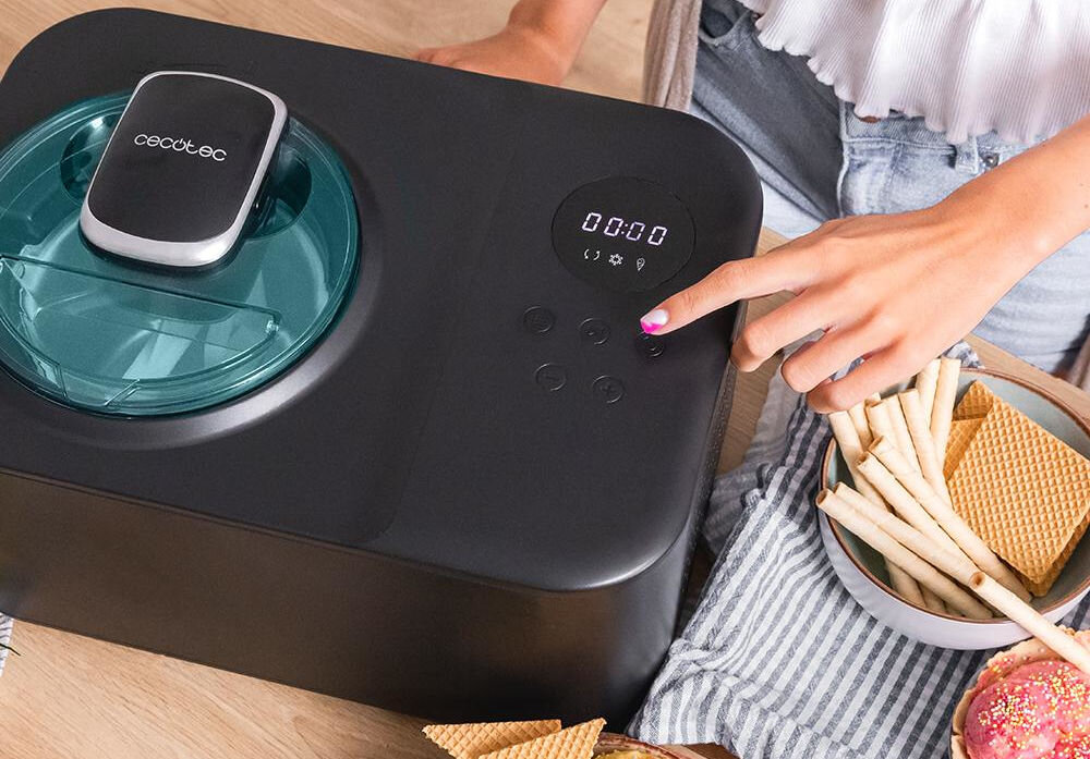 Maszynka do lodów CECOTEC Gelacy 1200 Touch maszynka przyciski wyświetlacz czarna obudowa osoba wciska przycisk  Wbudowany wyświetlacz funkcjonalne rozwiązanie ułatwienie obsługi pełna kontrola nad procesem obsługa za pomocą przycisków intuicyjna szybka obsługa dostosowanie parametrów czas mrożenia prędkość mieszania składników optymalne rezultaty 