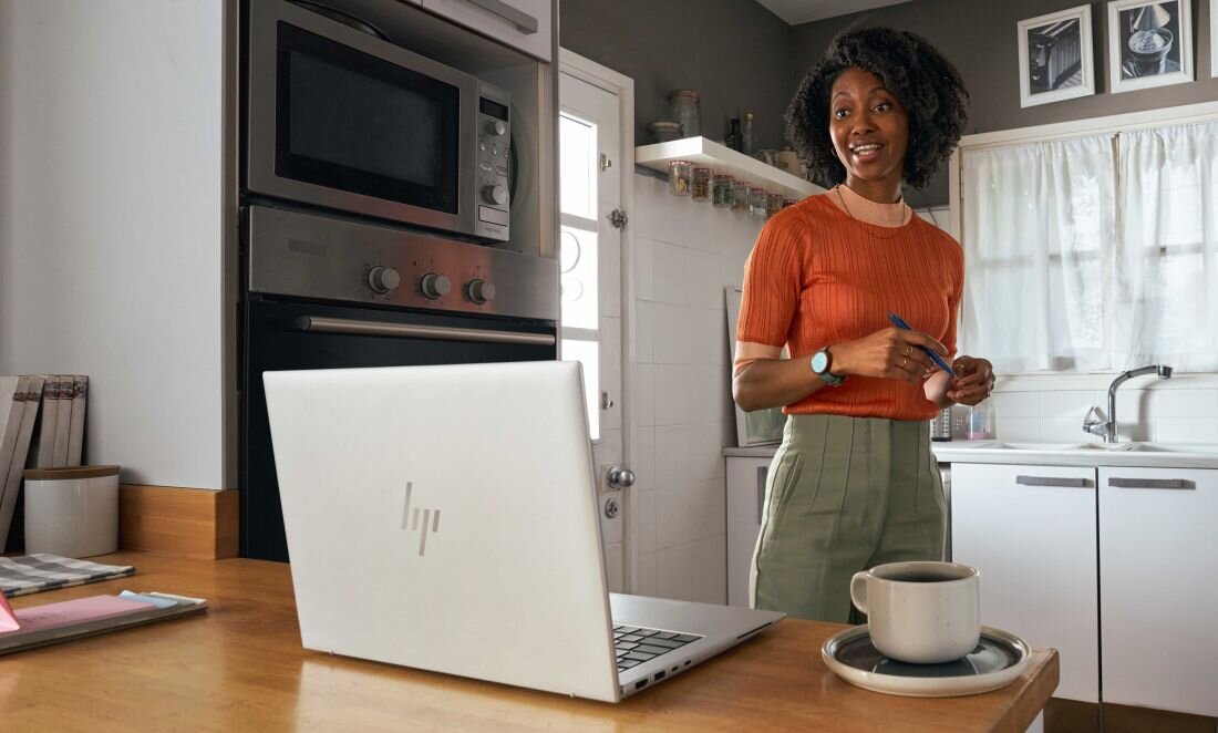 Laptop HP EliteBook 830 - Kobieta stoi przed laptopem HP EliteBook 830, skupiona na pracy przy komputerze. Szybka pamięć SSD, NVMe 
