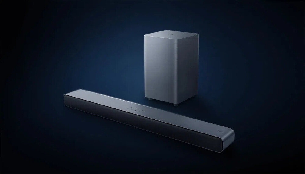 Soundbar TCL S55HE szczotkowany metal obudowa odporna na odciski design estetyka kino domowe, soundbar z subwooferem po skosie na ciemnoniebieskim tle