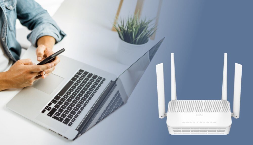 Router CUDY WR3000H Osoba trzymająca smartfon nad otwartym laptopem na białym biurku. Po prawej stronie znajduje się biały router z czterema antenami na niebieskim tle, opis