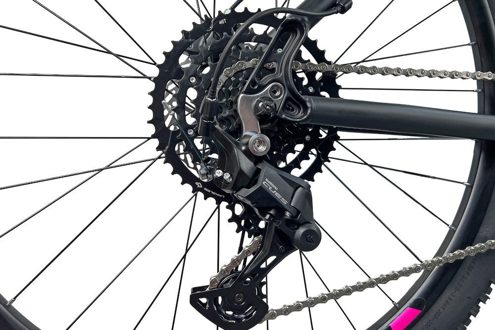 Rower górski MTB INDIANA X-Pulser 3.7 D21 27.5 cala damski Czarno-fuksjowy zbliżenie na tylną przerzutkę przerzutki marki przerzutki marki SHIMANO 9 biegów duża wytrzymałość sprawne działanie zmiana biegów jest płynna i bezproblemowa tylny napęd SHIMANO CUES niewiarygodnie płynna szybka zmiana przełożeń wytrzymałość