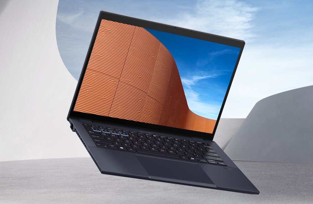 Laptop ASUS ExpertBook B5404CMA-Q50339X Laptop z otwartą klapą, wyświetlający na ekranie zdjęcie architektury z pomarańczową fasadą i niebieskim niebem w tle, opis