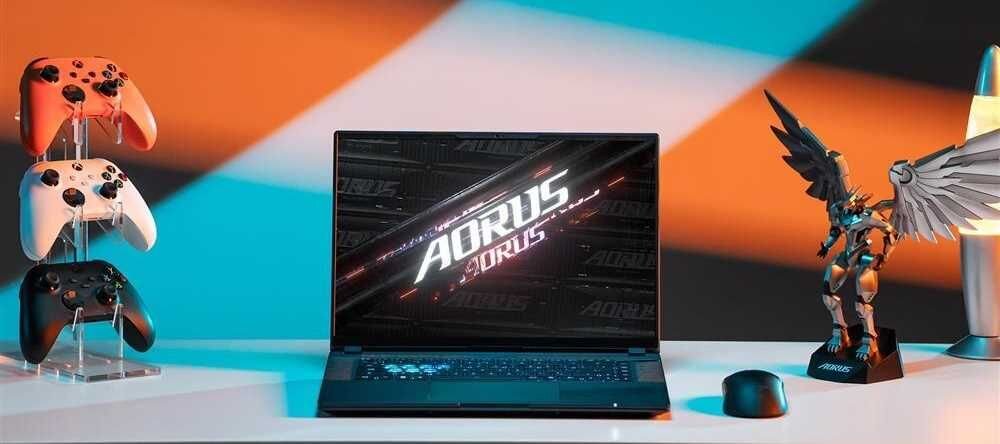 Laptop GIGABYTE Aorus 16X z gamingowym kontrolerem obok, gotowy do rozgrywki. - bateria o pojemności99 Wh 