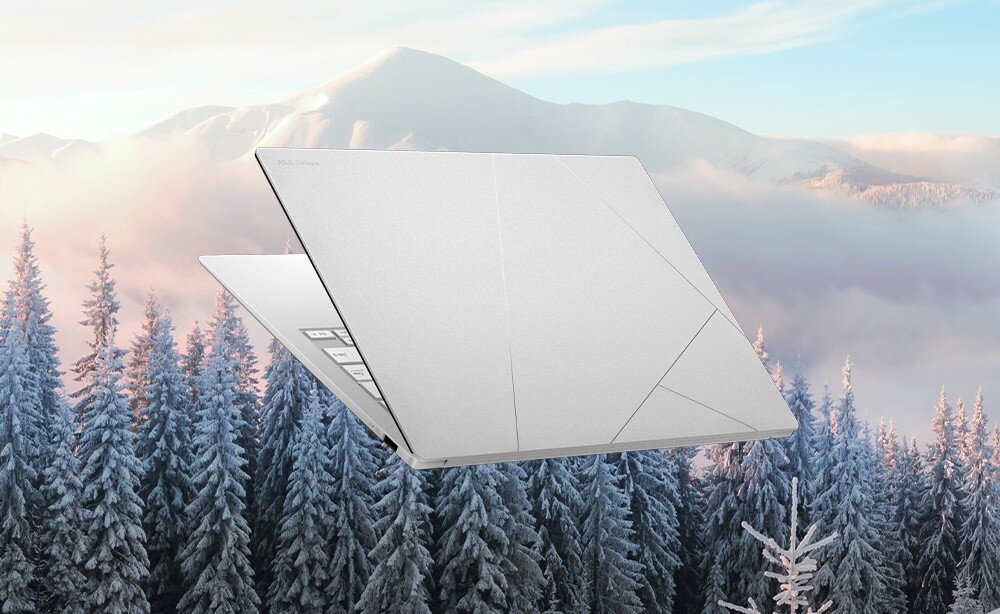 Laptop ASUS ZenBook S 14 UX5406SA-PV030W Zamknięty laptop unoszący się nad zimowym krajobrazem z ośnieżonymi drzewami i górami w tle, kolor, wygląd
