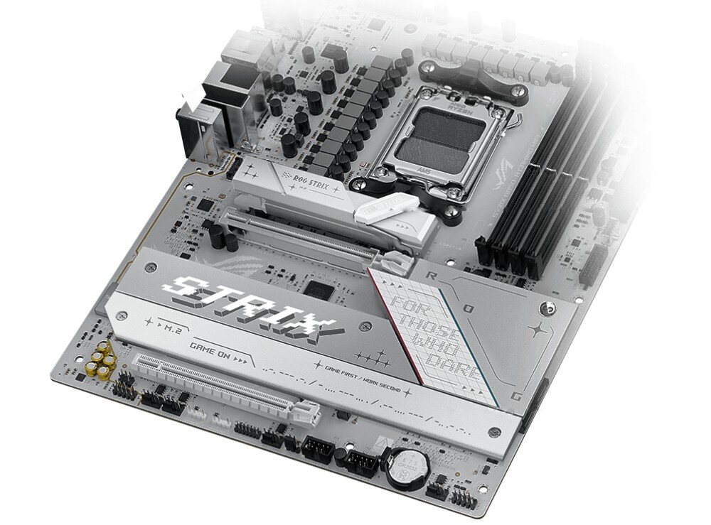 Płyta główna ASUS ROG Strix B850-A Gaming WiFi Dolna część płyty głównej z dużymi osłonami radiatorów i charakterystycznym logo STRIX, osadzone na białym laminacie