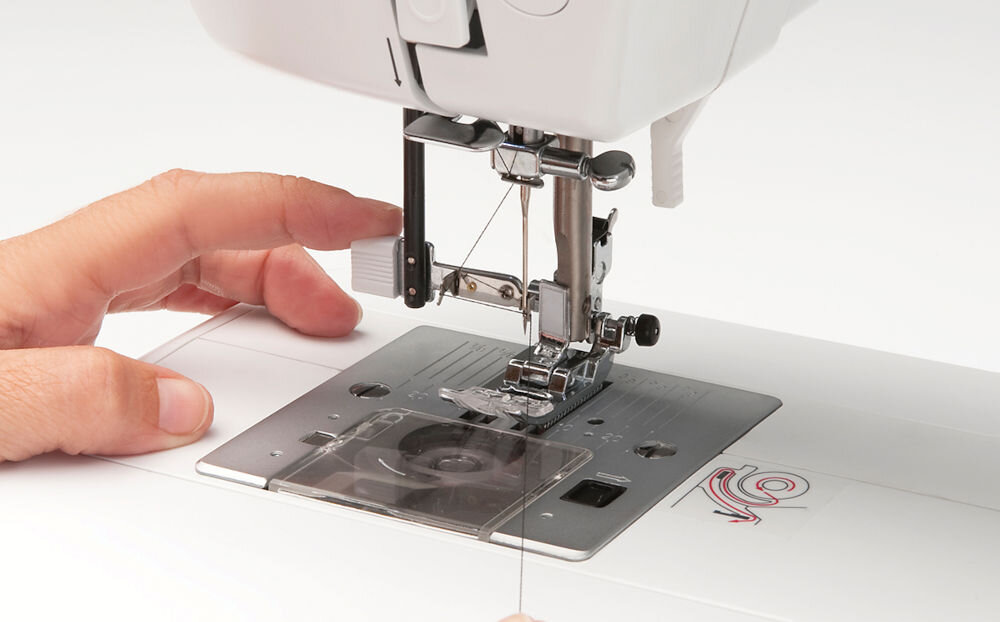 Hafciarka BERNETTE B79 + Program Bernina Creator V9 maszyna zbliżenie na stopkę  przyciski osoba trzyma nitkę Szybki i intuicyjny nawlekacz igły przygotowanie maszyny do pracy ułatwienie procesu szycia oszczędność czasu uniknięcie frustracji wygoda komfort użytkowania 