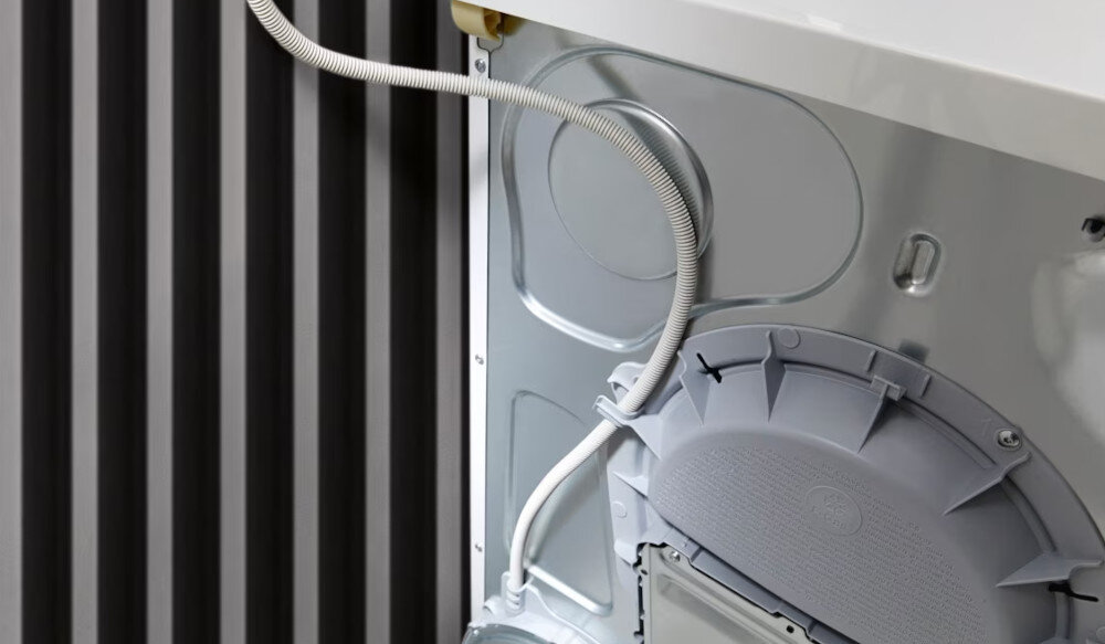 Suszarka MIELE TWC640WP EcoSpeed zdjęcie wizualizacyjne lifestyle tył suszarki wąż przyłącza  Wygodne odprowadzanie wody kondensacyjnej zwijacz węża do umywalki syfonu