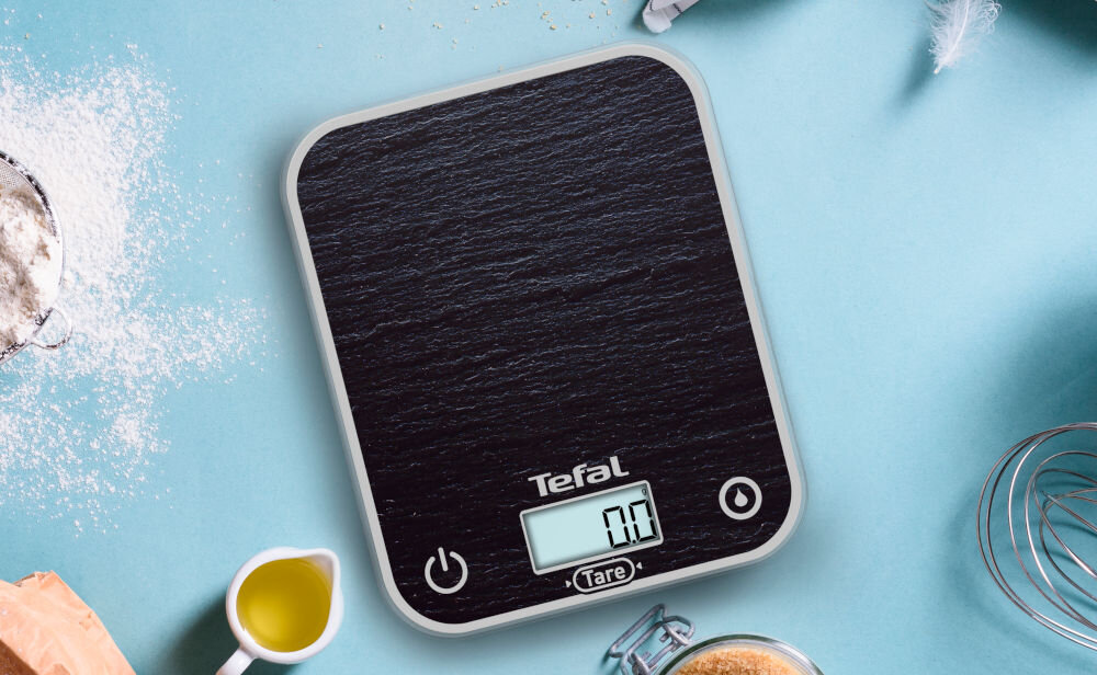 Waga kuchenna TEFAL BC50D2V0 niebieskie tło waga czarny kolor przyciski świecący wyświetlacz kuchenny sprzymierzeniec precyzyjność praktyczne podejście dokładność pomiaru do 0,5 g funkcjonalne narzędzie w kuchni 