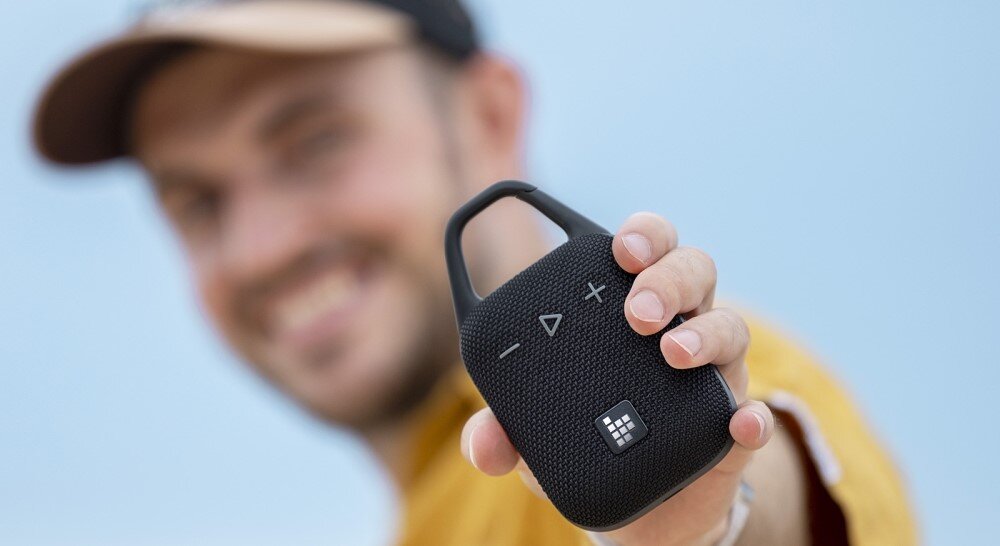 Głośnik mobilny TRONSMART Mirtune H1 kompaktowy przenośny design, osoba trzymająca głośnik w ręku