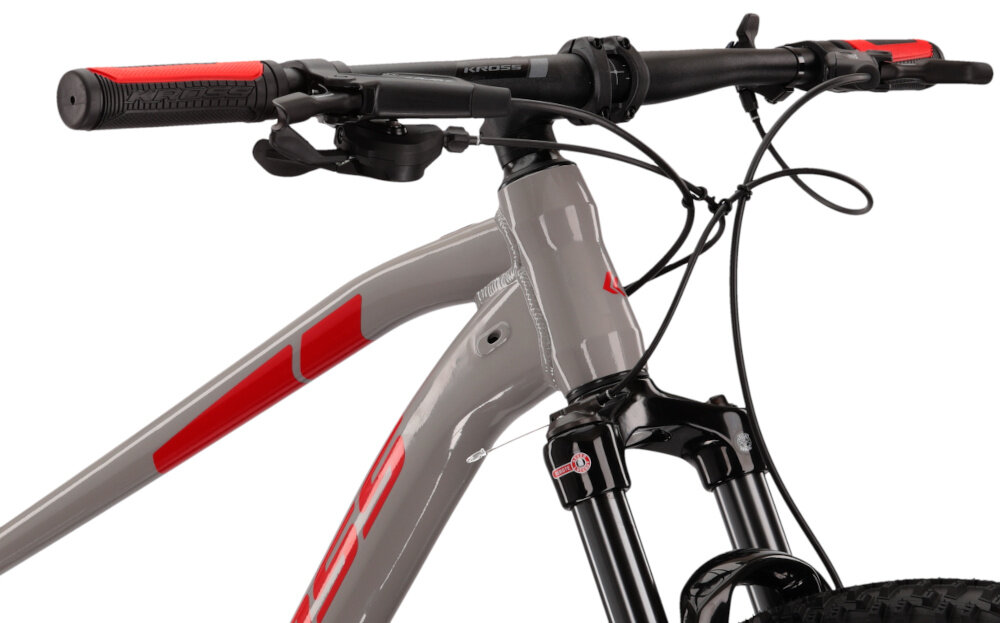 Rower górski MTB KROSS Level 4.0 M17 29 cali męski Szaro-czerwony zbliżenie na kierownicę kierownica widoczna od przodu pod skosem aluminiowa kierownica aluminiowy wspornik KROSS lekkość trwałość manetki pokryte antypoślizgowym materiałem pewny chwyt
