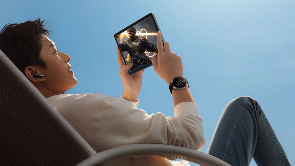 Tablet OSCAL Pad 9 10.1 cali 4/128 GB Wi-Fi LTE Szary prezentacja urządzenia podczas codziennego korzystania mężczyzna trzymający tablet leżący na leżaku na dworze granie w gry